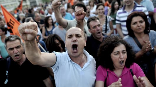 Municipality employees shout slogans against the Greek Government in front of the Greek Parliament during a demonstration as Greek lawmakers prepared to vote late Wednesday on a controversial new austerity package involving a huge shake-up of the civil service with thousands of jobs on the line.